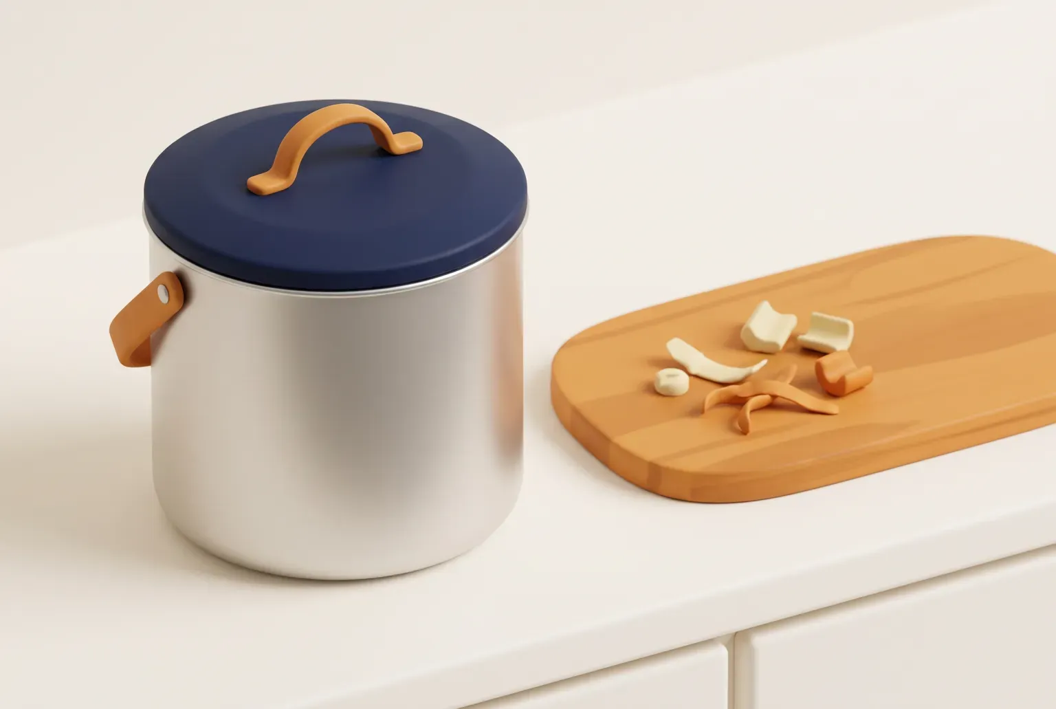 Illustration: a silver countertop bin with a navy lid and an amber handle on a cream kitchen counter beside a wooden cutting board with a few vegetable scraps, drawn as a soft 3D render. Not a real product.