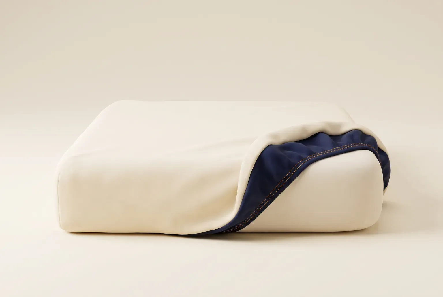 Illustration: a cream mattress with its cover peeled back at one corner to show a navy lining with orange stitching. Not a real product.